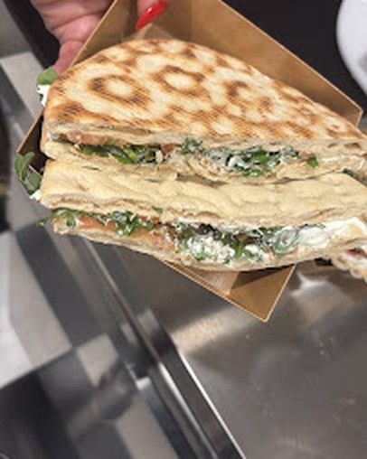 Panini grillé garni de poulet, roquette et mozzarella, servi dans sa boîte kraft
